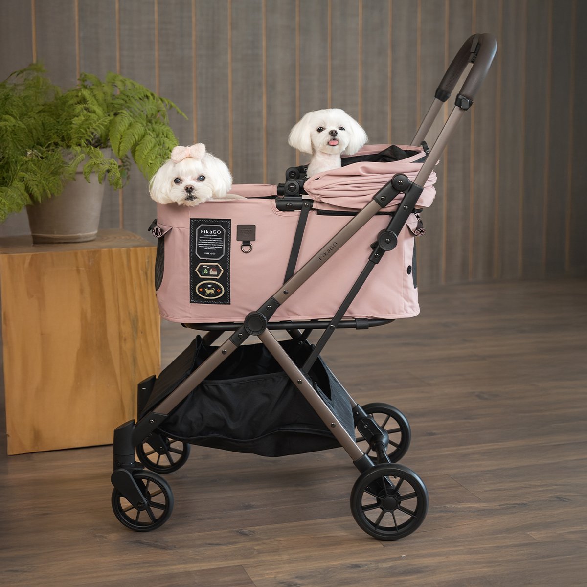 Two small dog are sitting in FikaGO FREE TO GO 2 stroller in mist pink