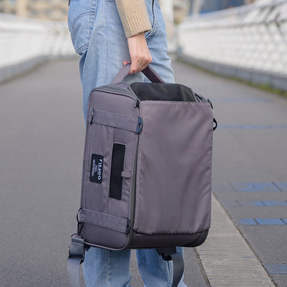 Person carrying FikaGO TRUFFLE carry-on pet bag by the top handles