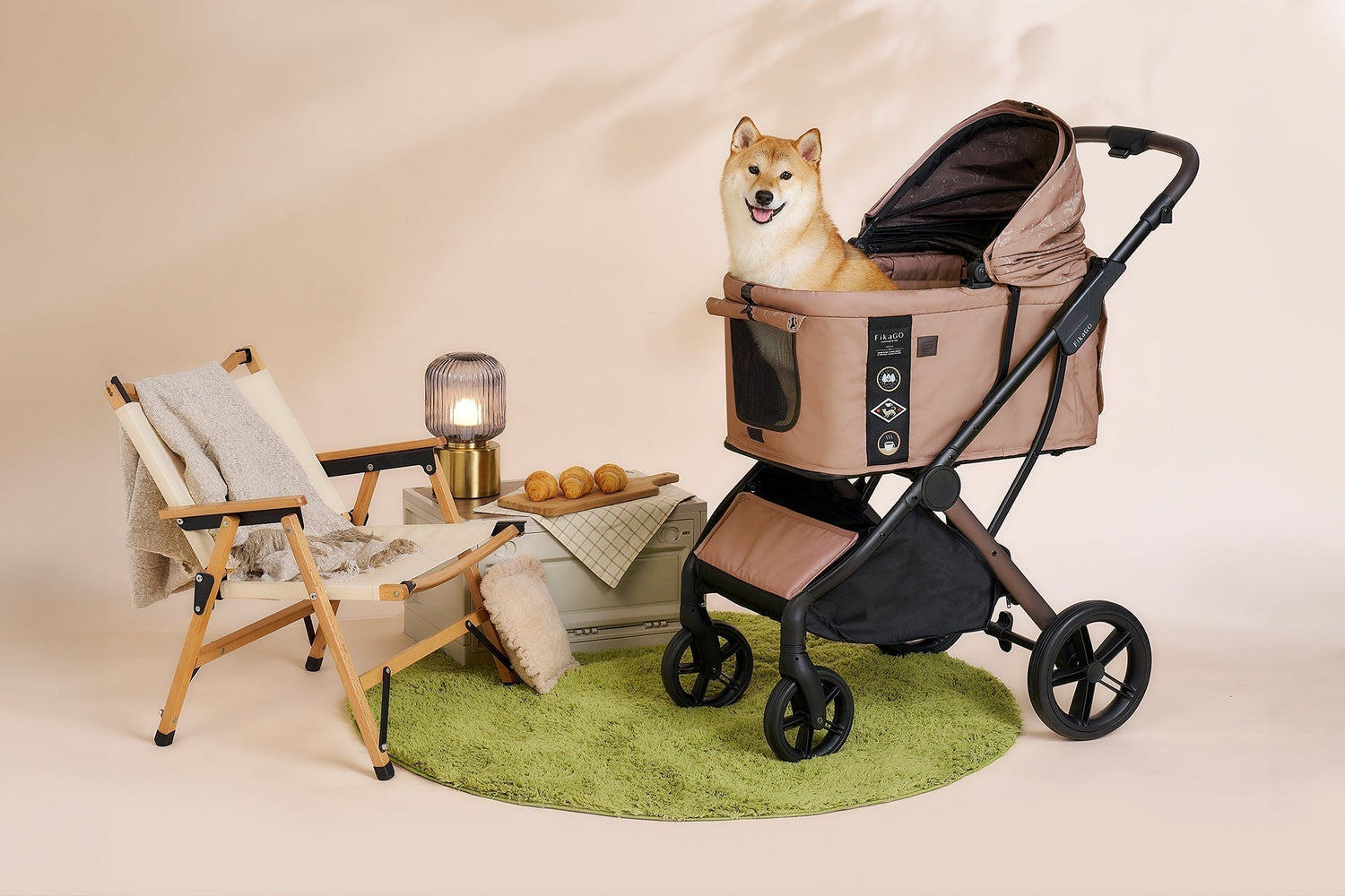 A two-panel image of a happy Shiba Inu in a taupe FikaGO pet stroller. The left panel shows a cozy indoor glamping setup, and the right panel is a closer view of the dog smiling in the carrier.